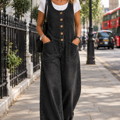 Bethany black denim dungarees worn by a woman walking in London