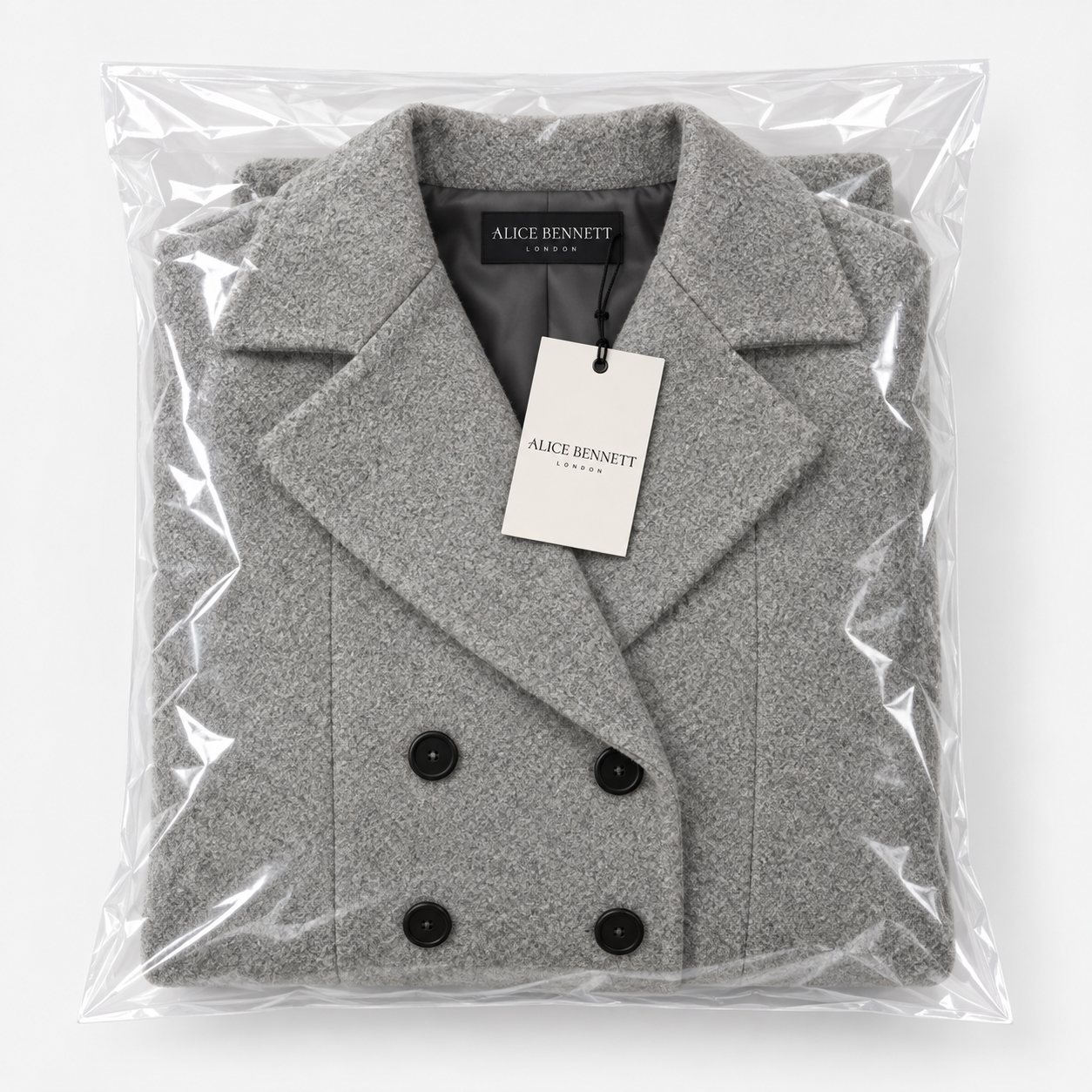 Folded grey longline coat in Alice Bennett London packaging