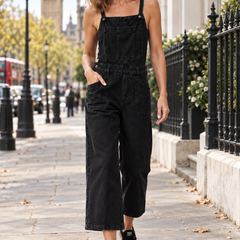 Elizabeth black denim cropped dungarees worn by a mature woman walking in London
