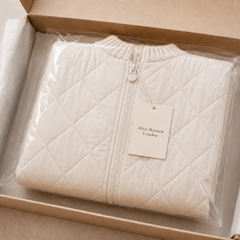 Folded ivory Knitpuff quilted jacket in Alice Bennett London packaging